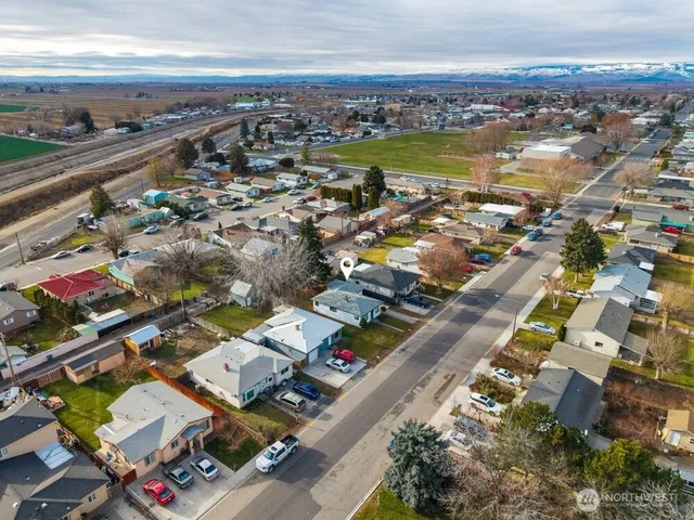 an aerial view of a city with lots of residential buildings and ocean view in back