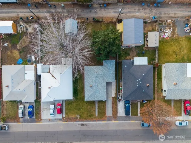 an aerial view of multiple houses with a street