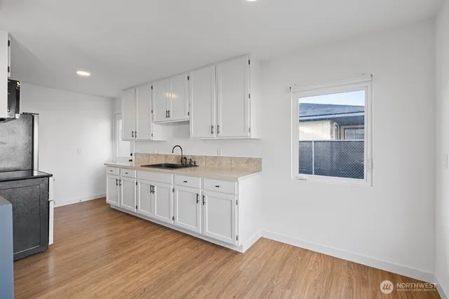 a kitchen with granite countertop white cabinets and white appliances