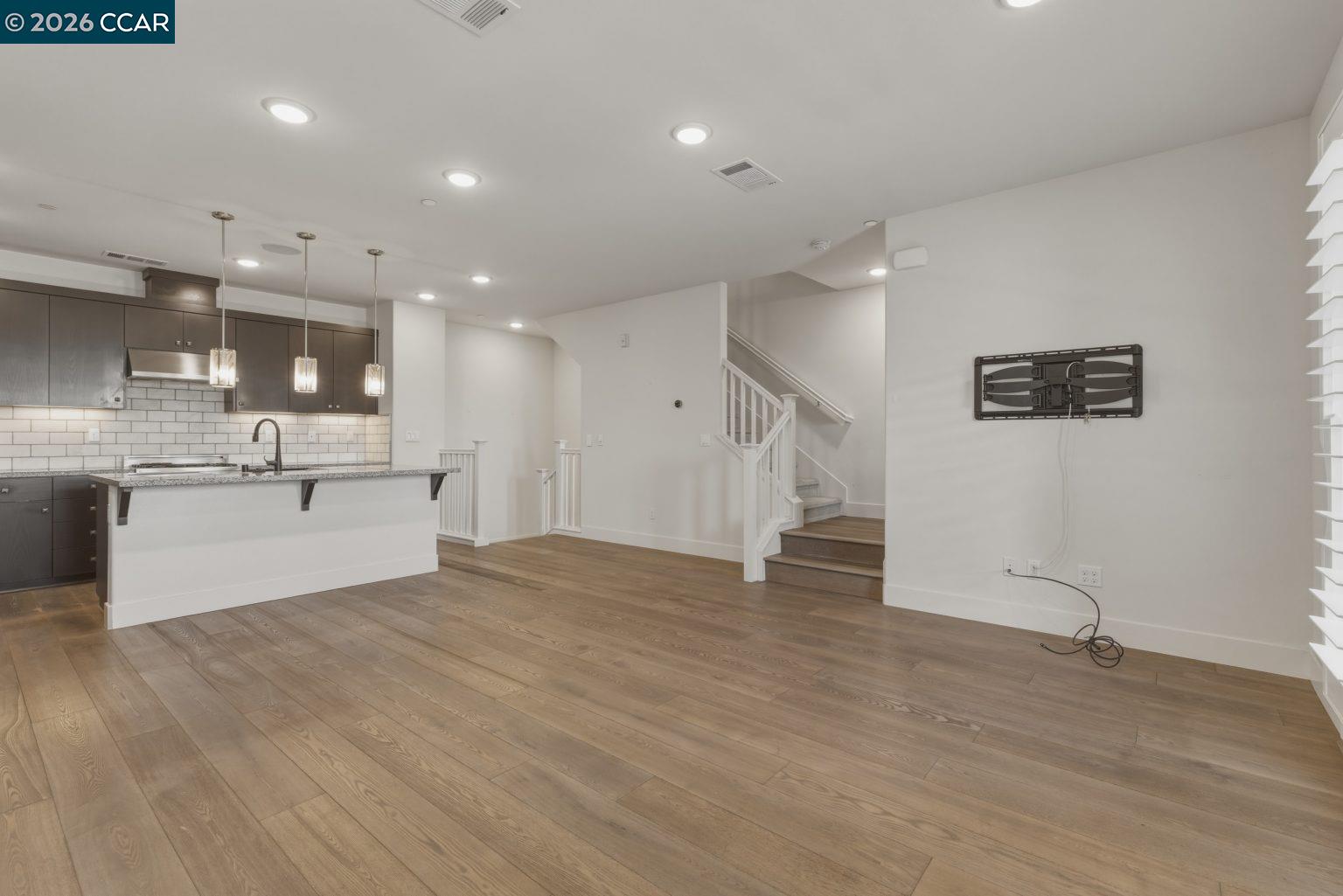 2737 5th Street Alameda, CA 94501 - Photo 7 of 37 a view of an empty room with wooden floor and a kitchen