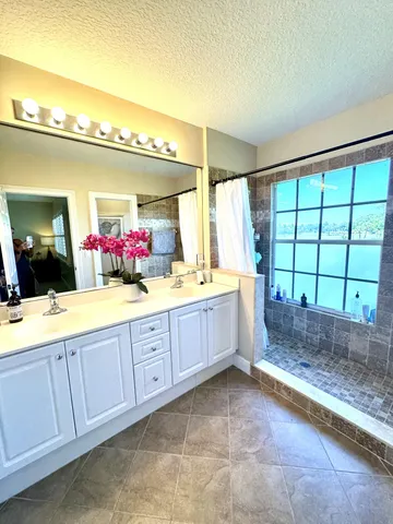 a spacious bathroom with a mirror a sink and a large window
