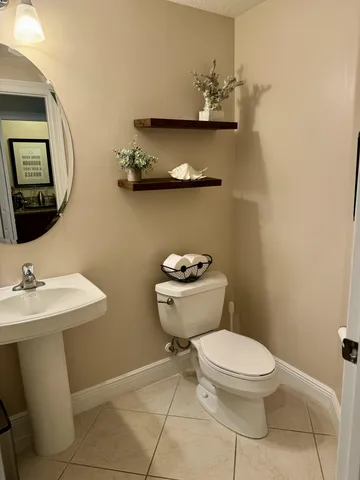 a bathroom with a toilet a sink and mirror