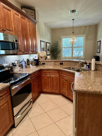 a kitchen with stainless steel appliances granite countertop a sink stove and cabinets