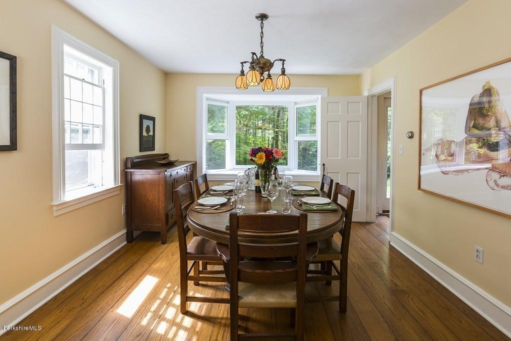 635 Reservoir Road Otis, MA 01029 - Photo 12 of 30 a dining room with furniture a chandelier and wooden floor