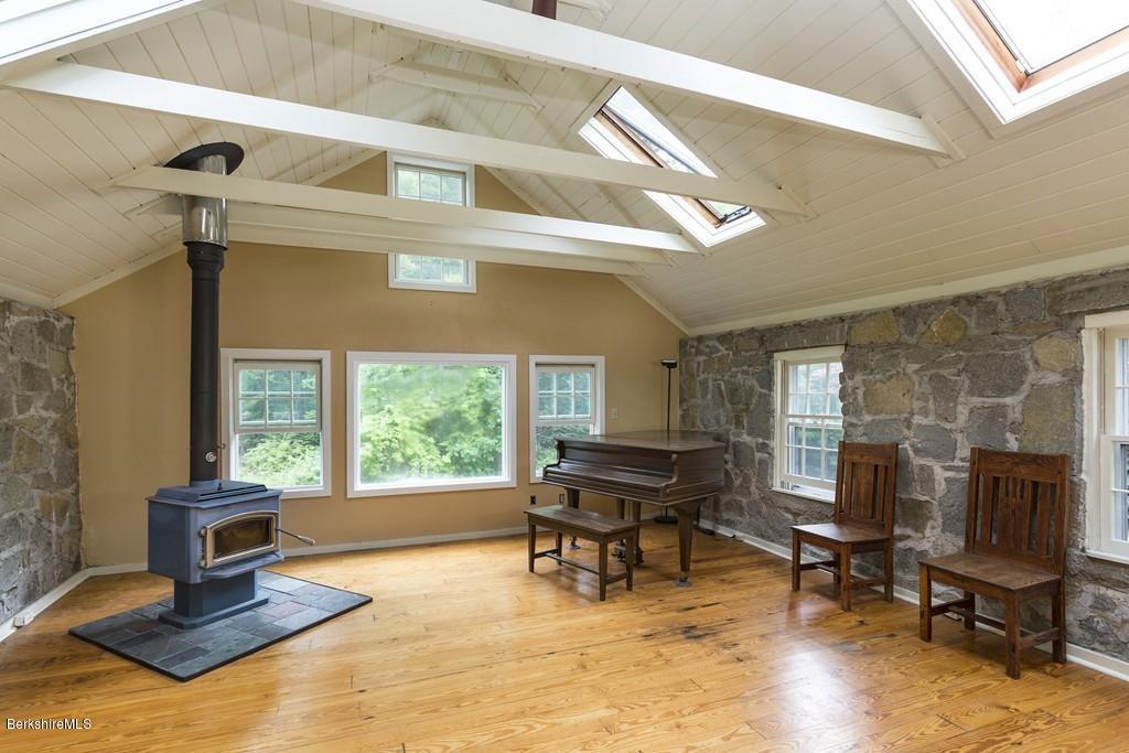 635 Reservoir Road Otis, MA 01029 - Photo 18 of 30 a living room with furniture a piano and a fireplace