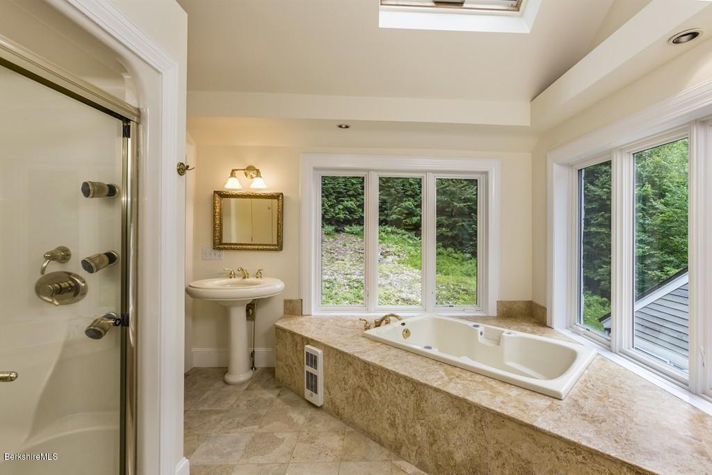 635 Reservoir Road Otis, MA 01029 - Photo 21 of 30 a bathroom with a granite countertop tub a sink and a large window