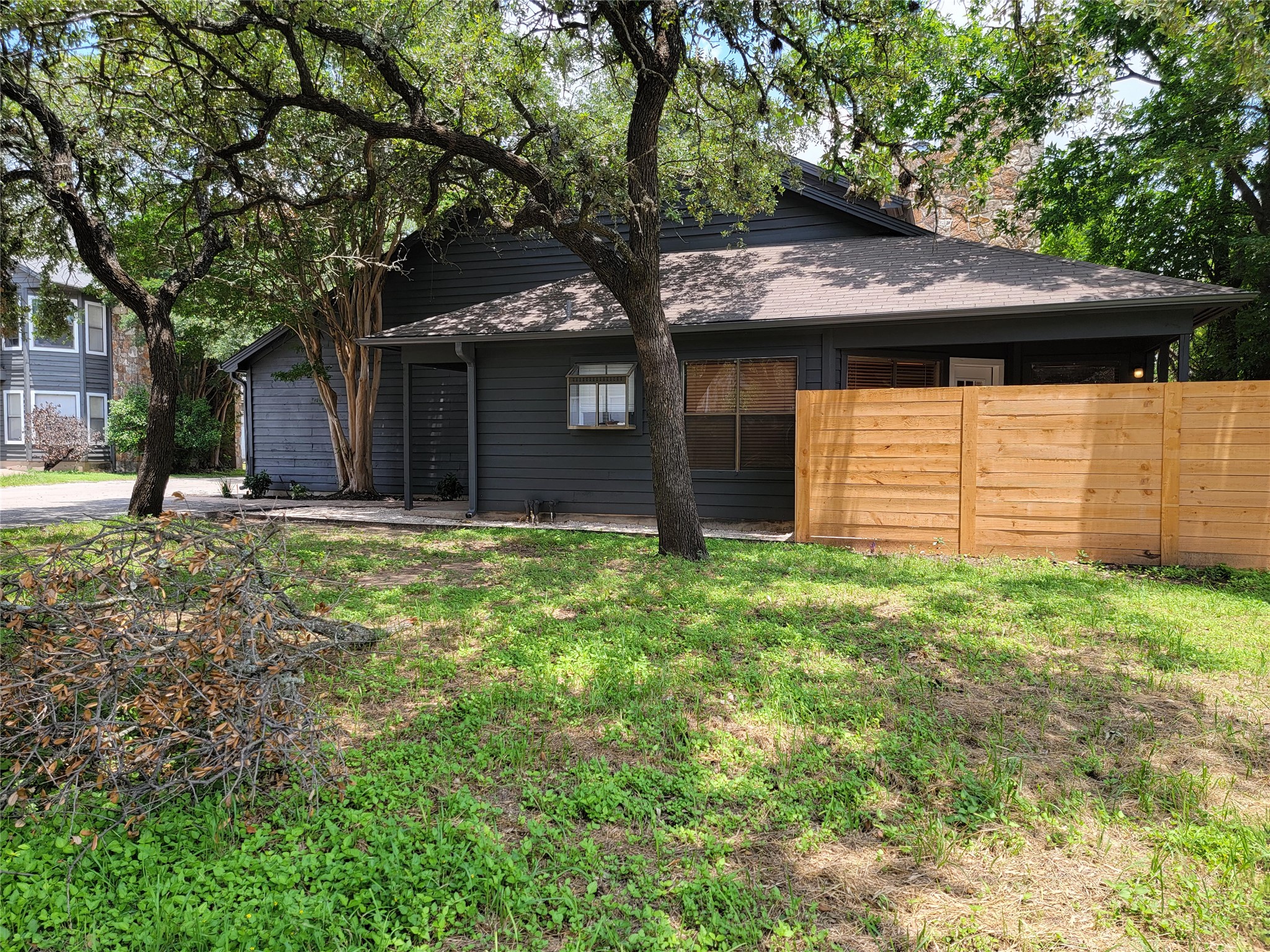 8706 Schick Road, Unit A Austin, TX 78729 - Photo 5 of 33 Mature trees and a new privacy fence frame the entrance to this attractive home.