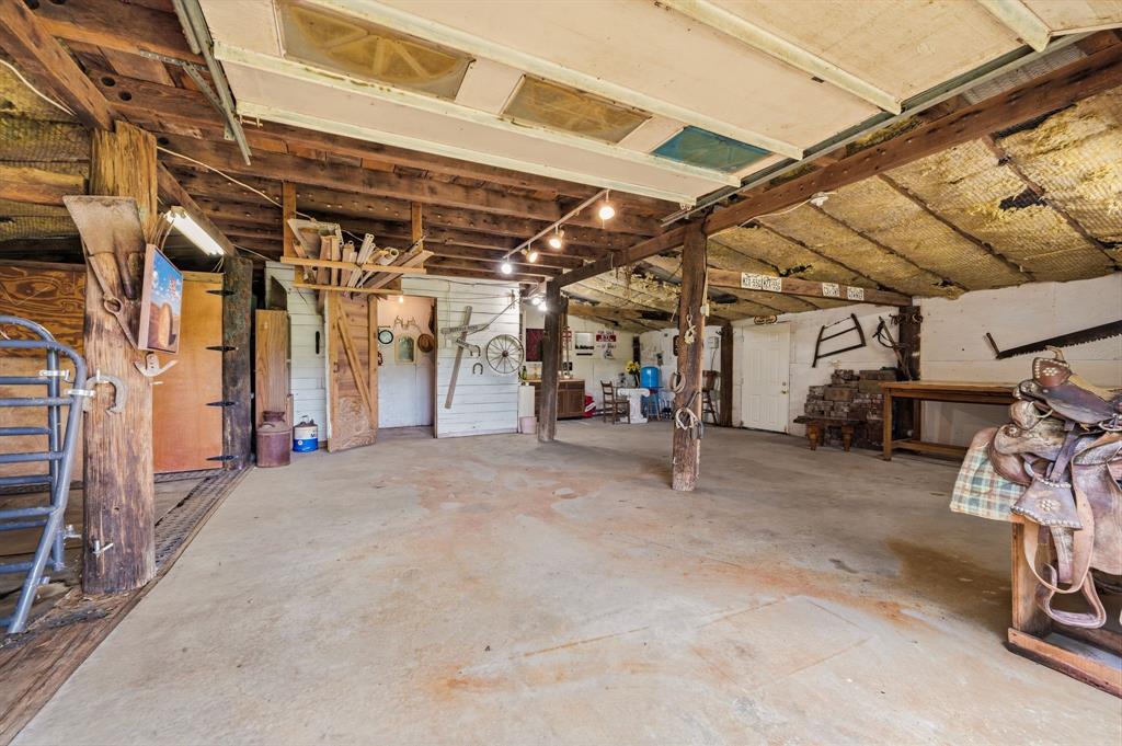 1805 Renfro Road Colleyville, TX 76034 - Photo 31 of 40 Spacious interior of barn with exposed wood beam ceiling, concrete flooring, and multiple wood doors
