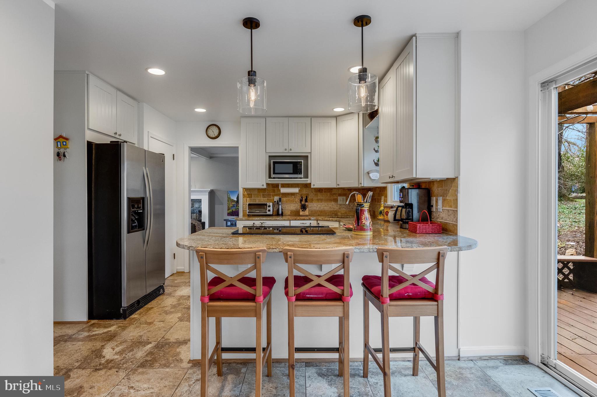 1700 Chester Mill Road Silver Spring, MD 20906 - Photo 11 of 53 a kitchen with stainless steel appliances granite countertop a stove refrigerator a dining table and chairs with wooden floor