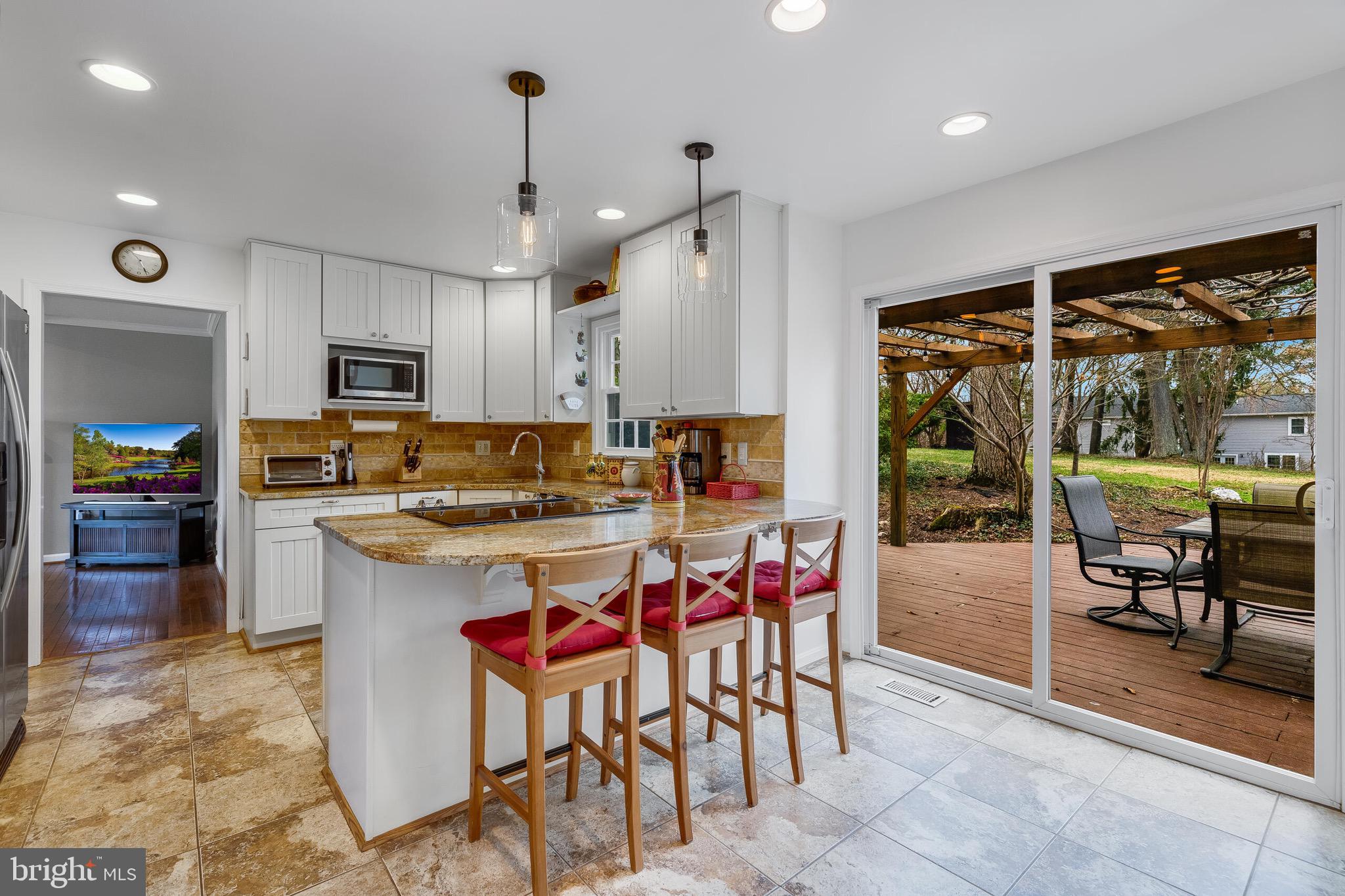 1700 Chester Mill Road Silver Spring, MD 20906 - Photo 12 of 53 a kitchen with stainless steel appliances granite countertop a stove top oven a sink a dining table and chairs with wooden floor