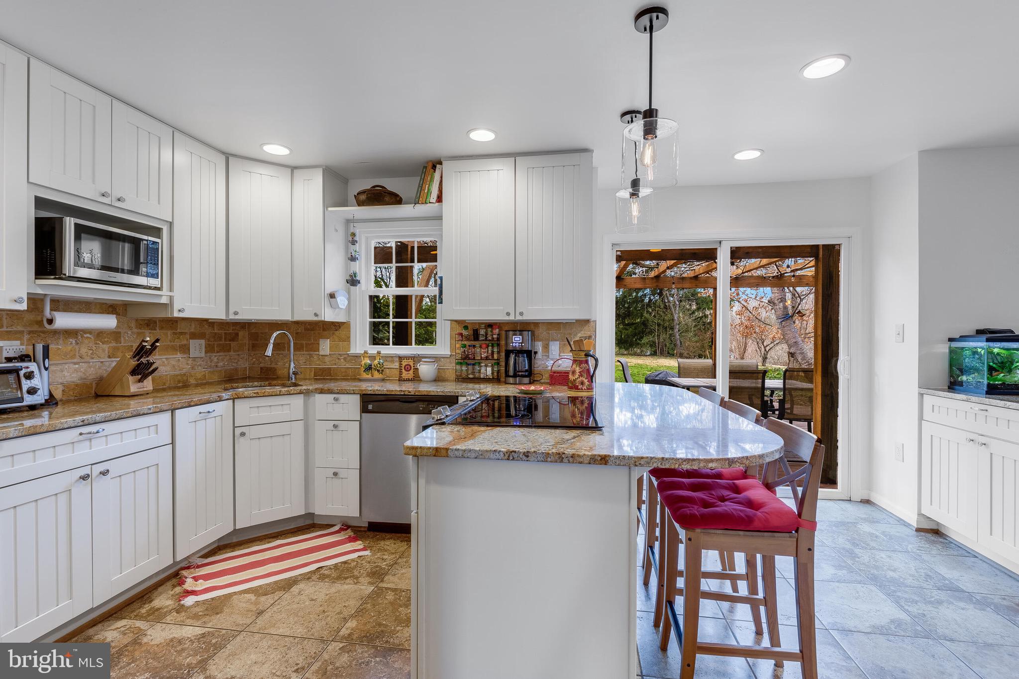 1700 Chester Mill Road Silver Spring, MD 20906 - Photo 13 of 53 a kitchen with kitchen island granite countertop a sink and white cabinets