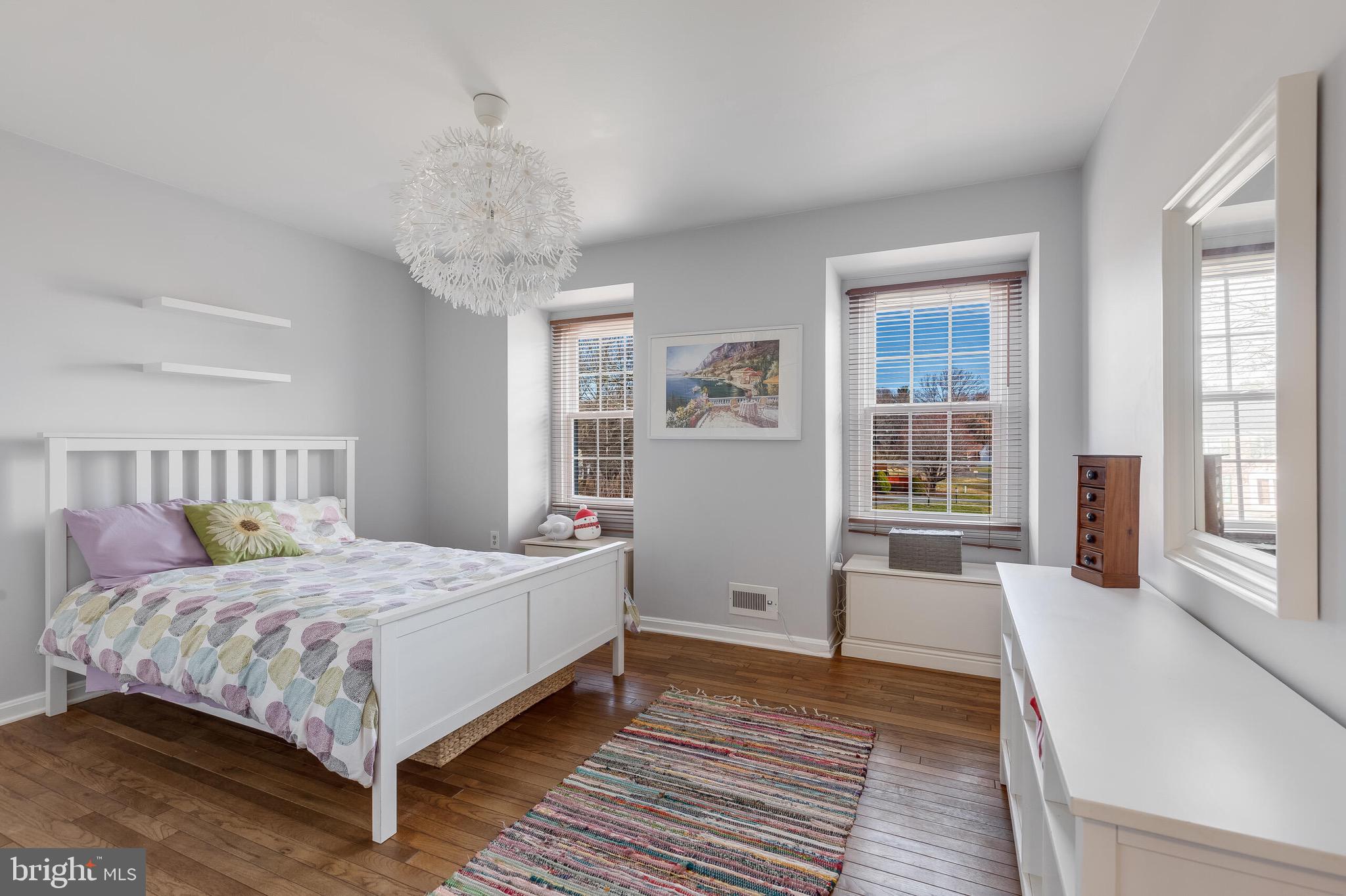 1700 Chester Mill Road Silver Spring, MD 20906 - Photo 23 of 53 a bedroom with a large bed a chandelier and windows