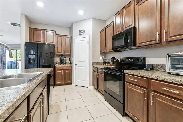 a kitchen with stainless steel appliances a sink stove refrigerator and cabinets