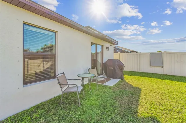 a view of a house with backyard and a tree