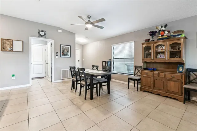 a kitchen with stainless steel appliances granite countertop a stove top oven a sink a dining table and chairs