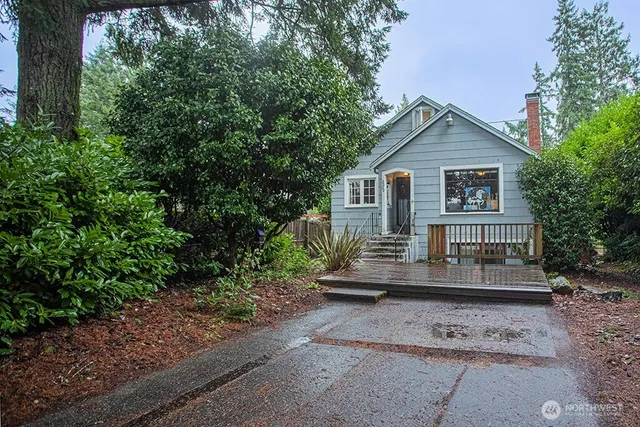 a view of a house with a yard and large tree