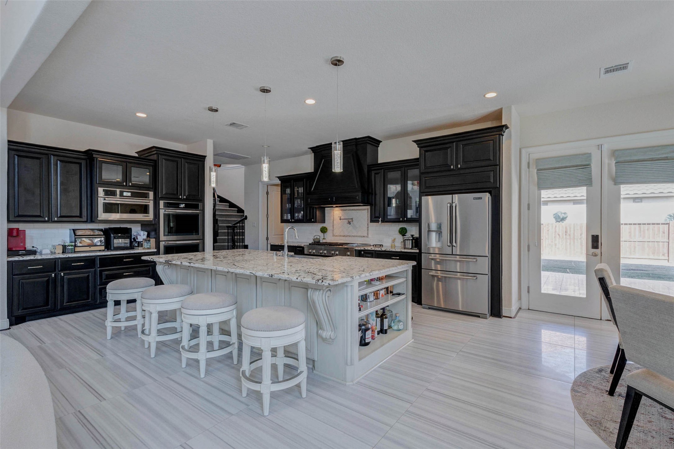 2310 Legends Way Katy, TX 77493 - Photo 11 of 50 a kitchen with stainless steel appliances a table chairs refrigerator and cabinets