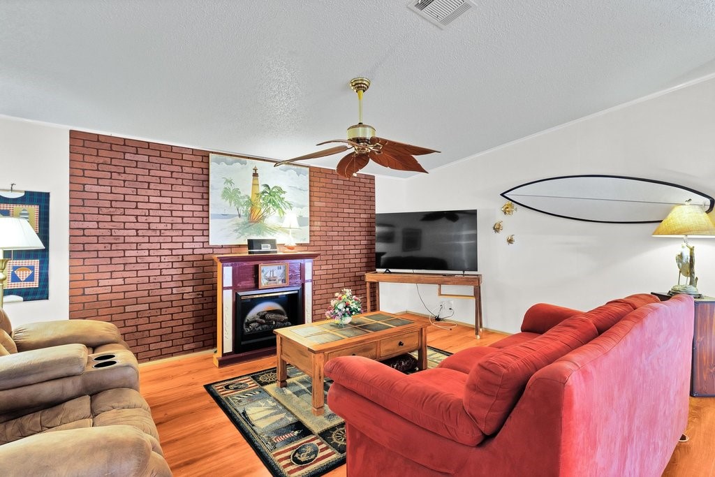 7605 Cedar Bark Road Sebastian, FL 32976 - Photo 6 of 34 a living room with furniture a flat screen tv and a fireplace