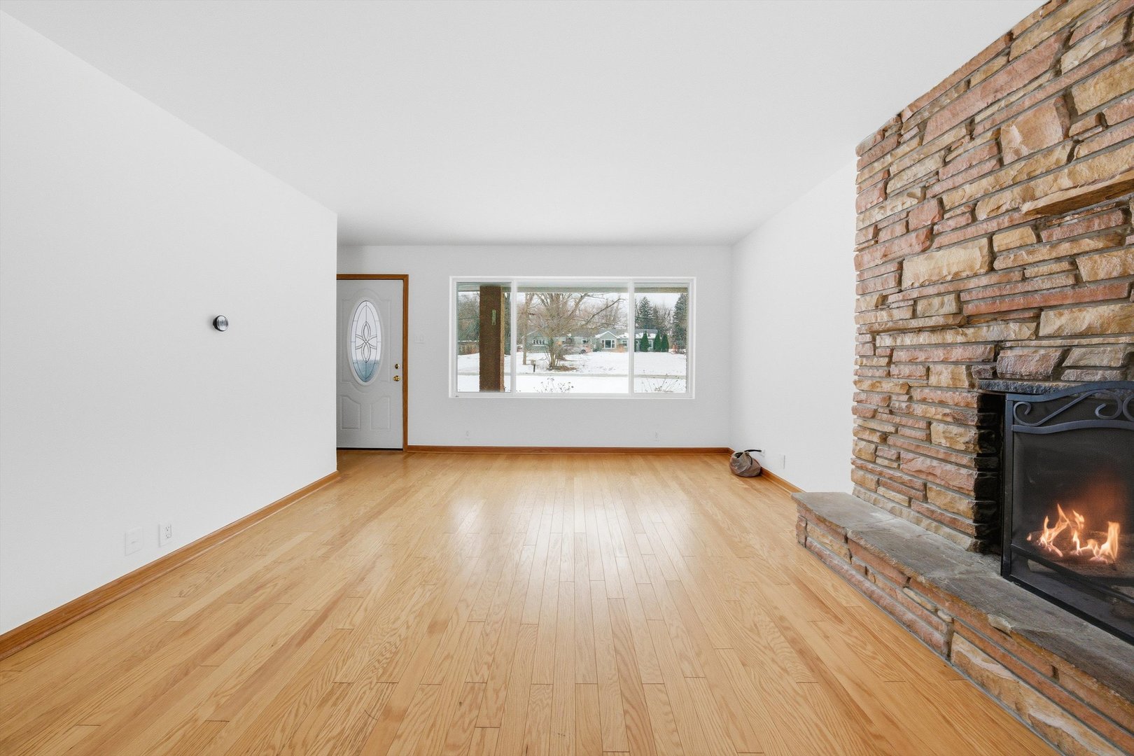 21122 Hillside Road Frankfort, IL 60423 - Photo 8 of 48 an empty room with windows a fireplace and wooden floor