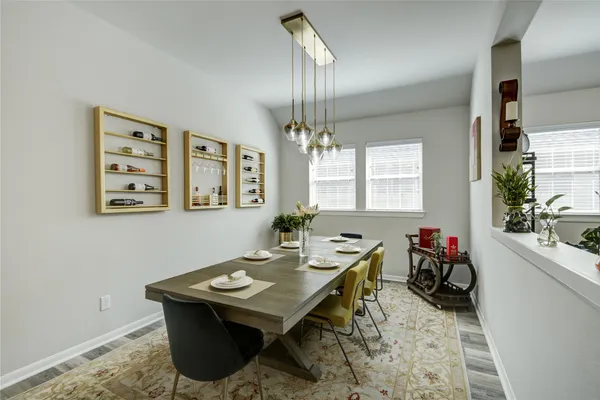 a living room with a table chairs and a chandelier