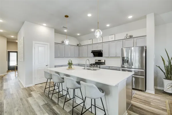 a kitchen with kitchen island appliances cabinets and wooden floor