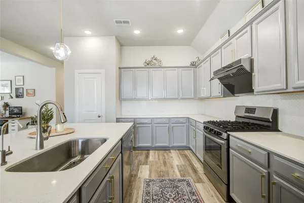 a kitchen that has a sink and a stove top oven