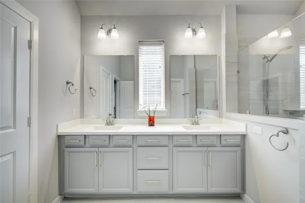 a bathroom with a sink double vanity and a mirror