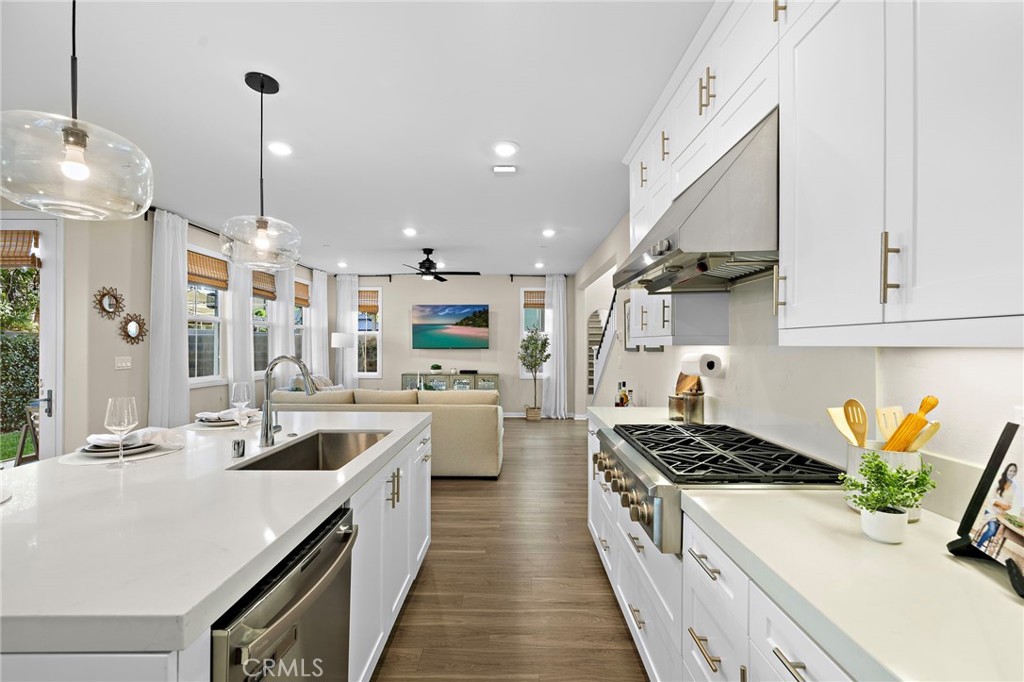 26 Paranza Place Rancho Mission Viejo, CA 92694 - Photo 7 of 65 a kitchen with stainless steel appliances a stove a sink dishwasher a refrigerator a oven and white cabinets with wooden floor