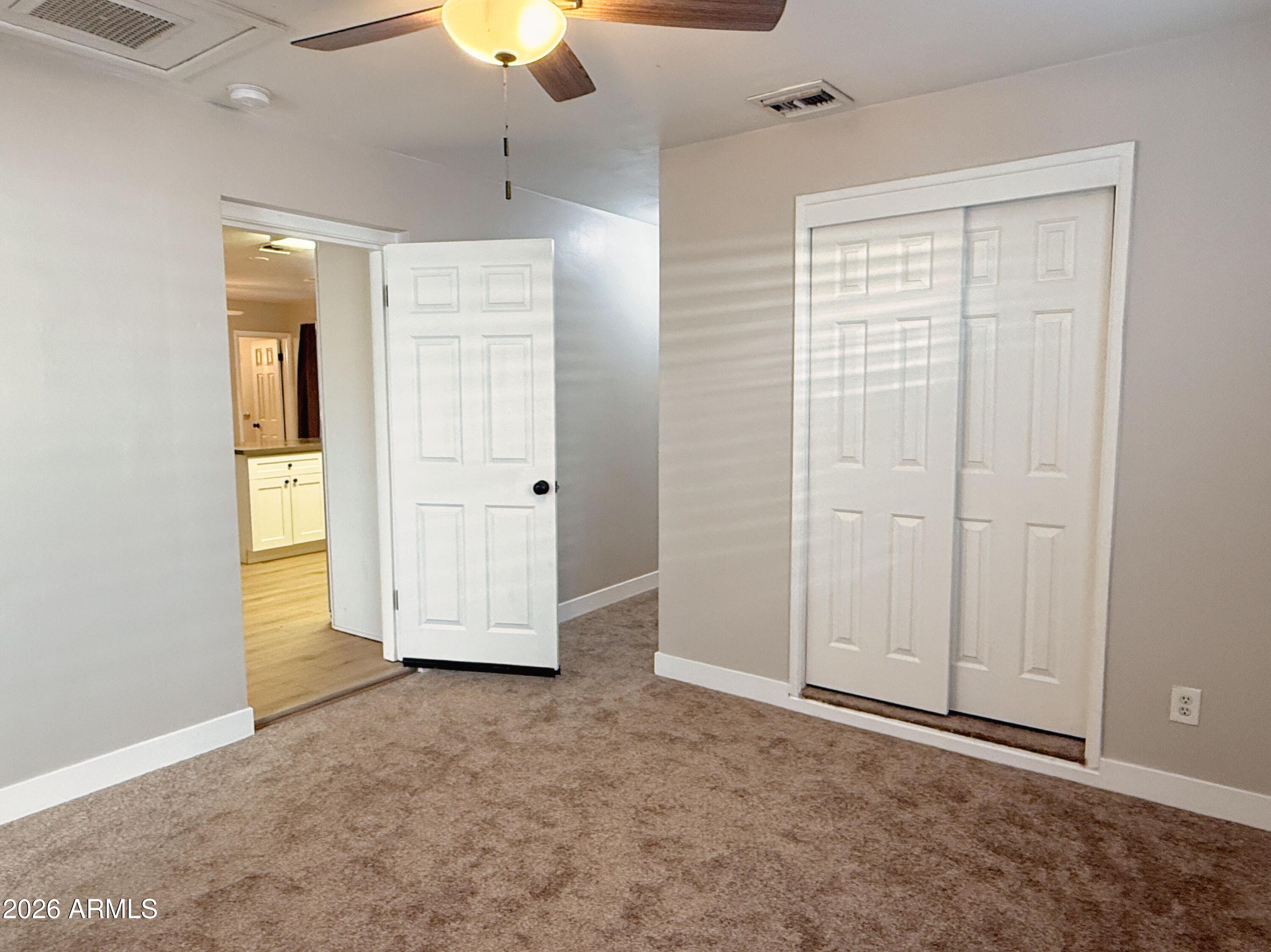 1220 West Romo Jones Street Tempe, AZ 85281 - Photo 11 of 26 an empty room with closet and a chandelier fan