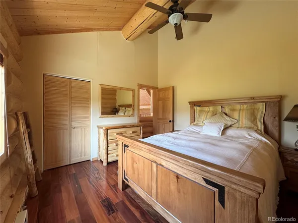 a bedroom with a bed and a flat tv screen on the dresser