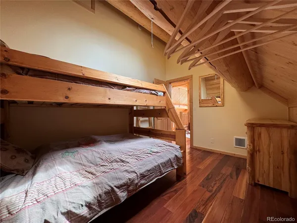 a bedroom with a bed and wooden floor