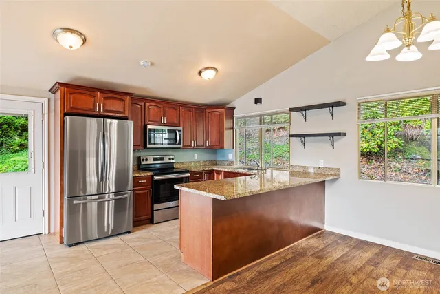 a kitchen with stainless steel appliances granite countertop a refrigerator and a stove