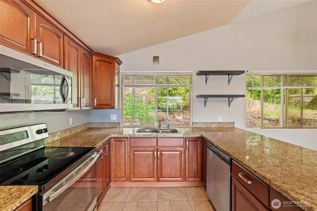 a kitchen with a sink a counter top space cabinets and window