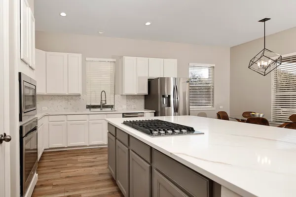 a kitchen with a table chairs stove and granite counter tops