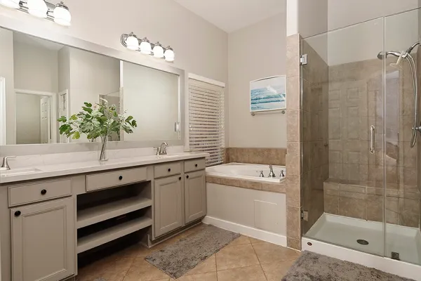 a spacious bathroom with a tub sink and mirror