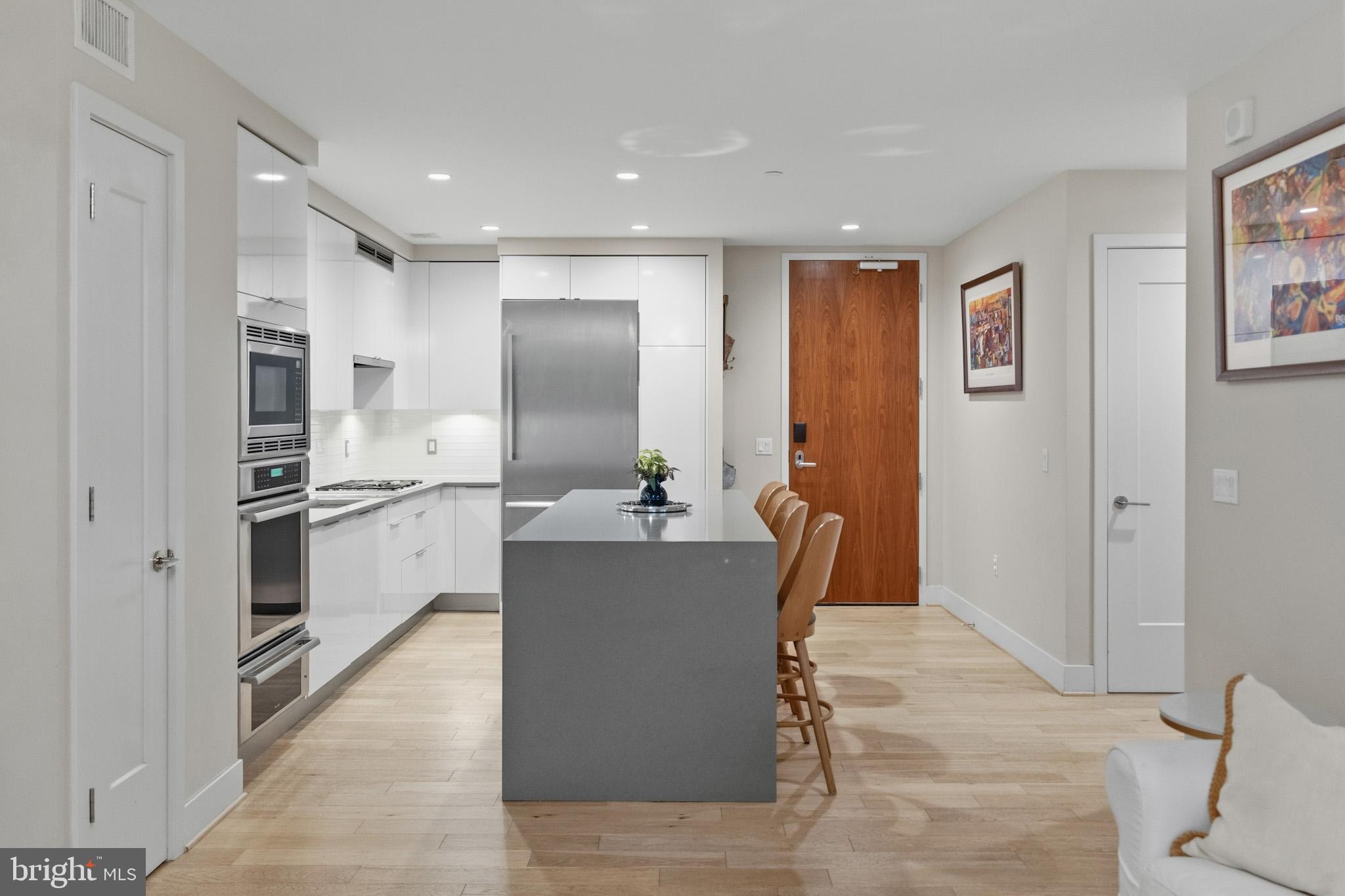 45 Sutton Square Southwest, Unit 403 Washington, DC 20024 - Photo 11 of 80 a view of kitchen with stainless steel appliances kitchen island a stove a refrigerator a sink a dining table and chairs