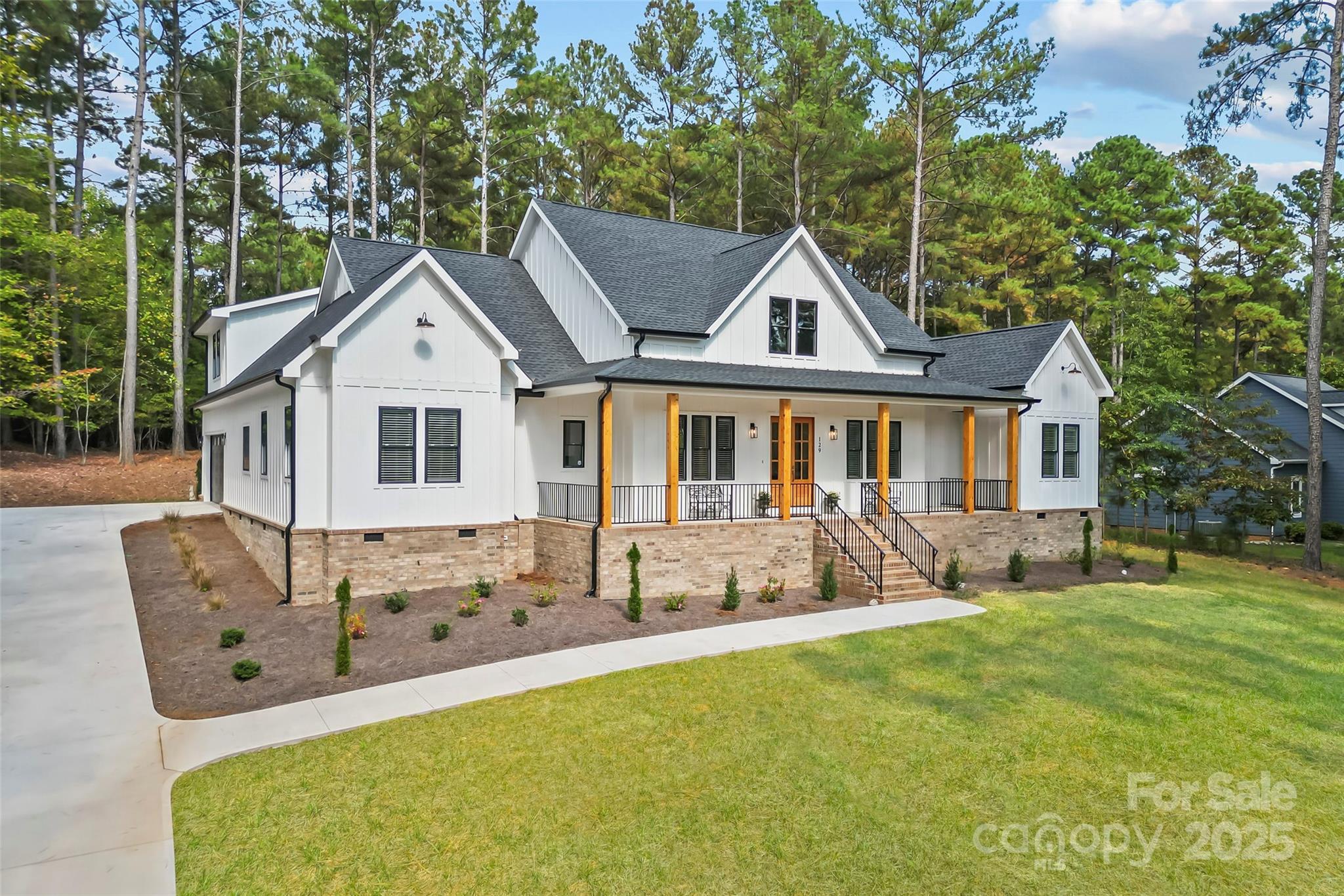a view of house with yard outdoor seating and covered with trees