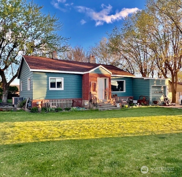 1006 East Dobson Road Odessa, WA 99159 - Photo 1 of 38 a front view of a house with a garden and trees