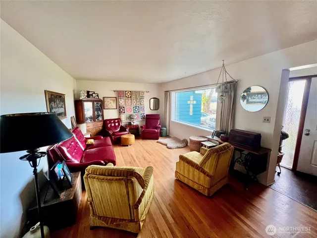 a living room with furniture a window and wooden floor