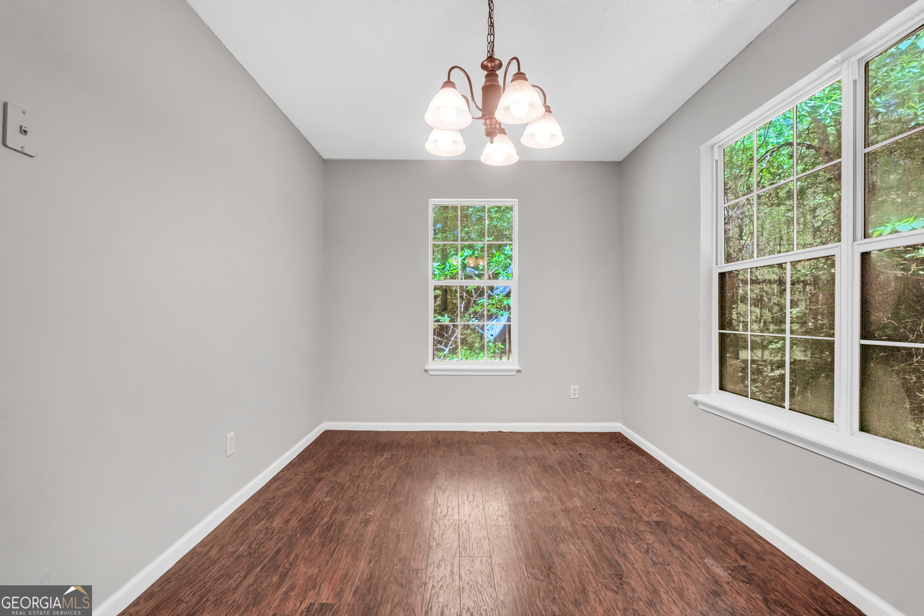 715 Concord Road Shady Dale, GA 31085 - Photo 12 of 38 an empty room with wooden floor and windows