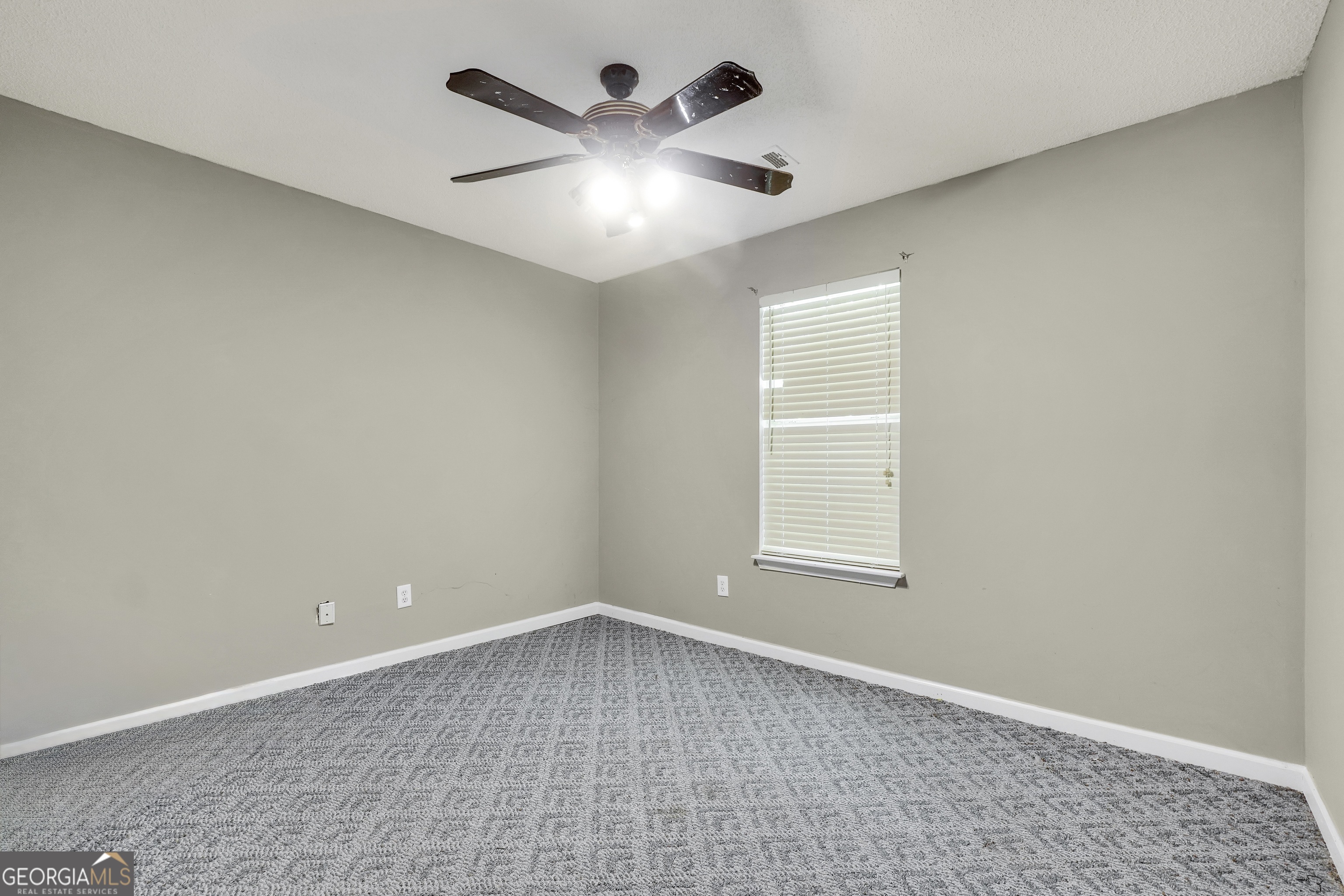 715 Concord Road Shady Dale, GA 31085 - Photo 19 of 38 an empty room with a window and a fan