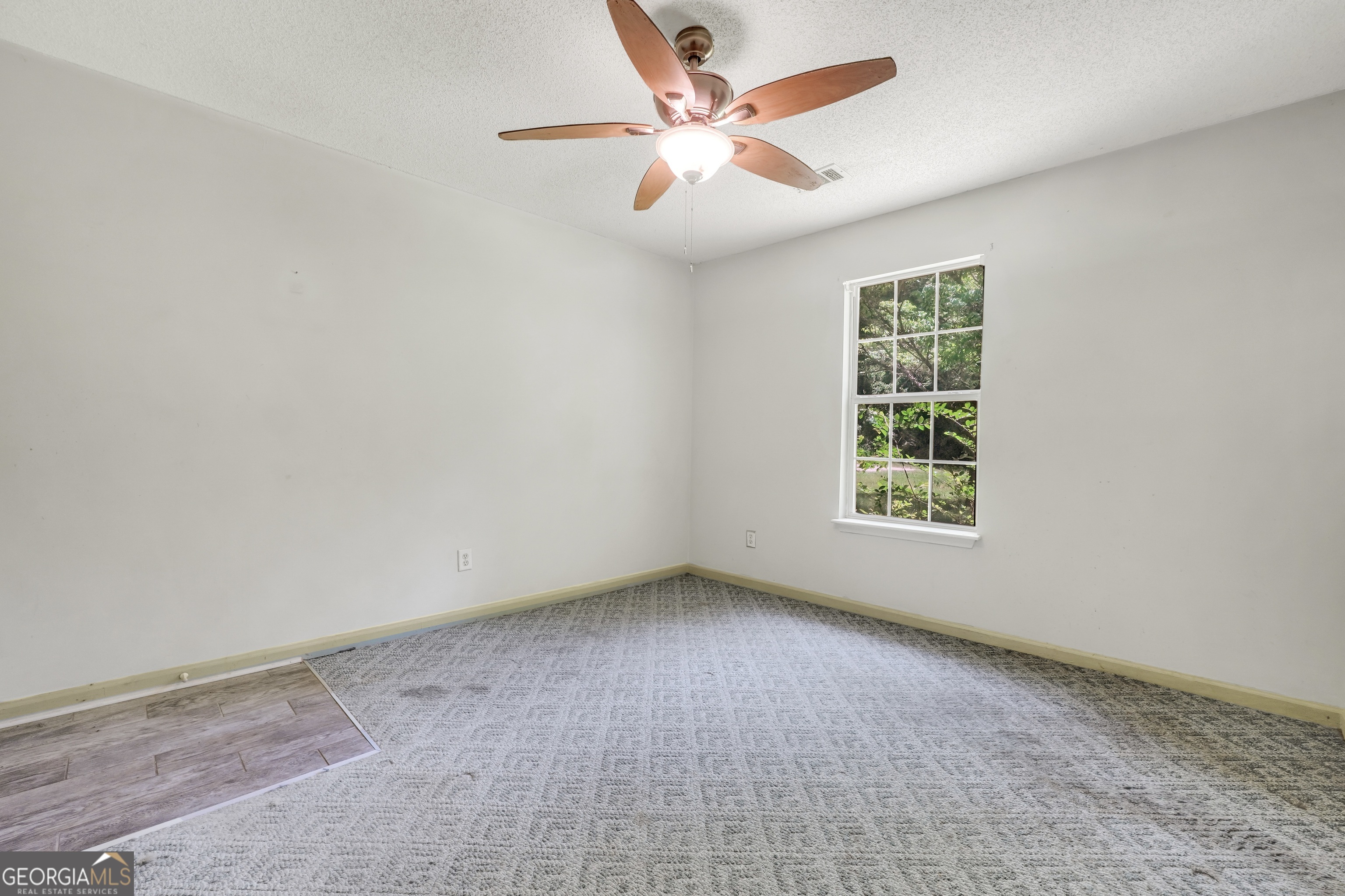 715 Concord Road Shady Dale, GA 31085 - Photo 22 of 38 an empty room with a window and a fan