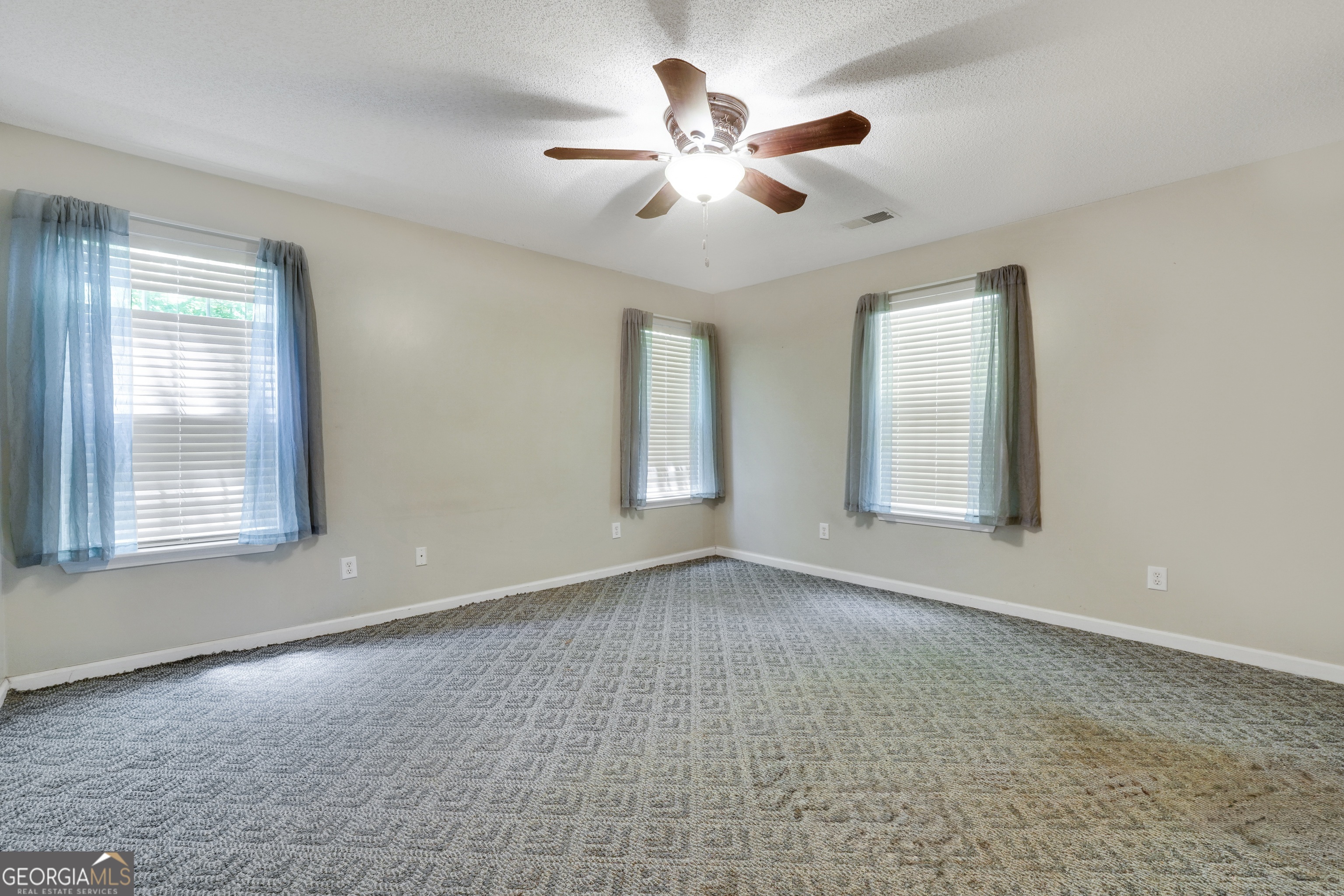 715 Concord Road Shady Dale, GA 31085 - Photo 24 of 38 an empty room with chandelier fan and windows