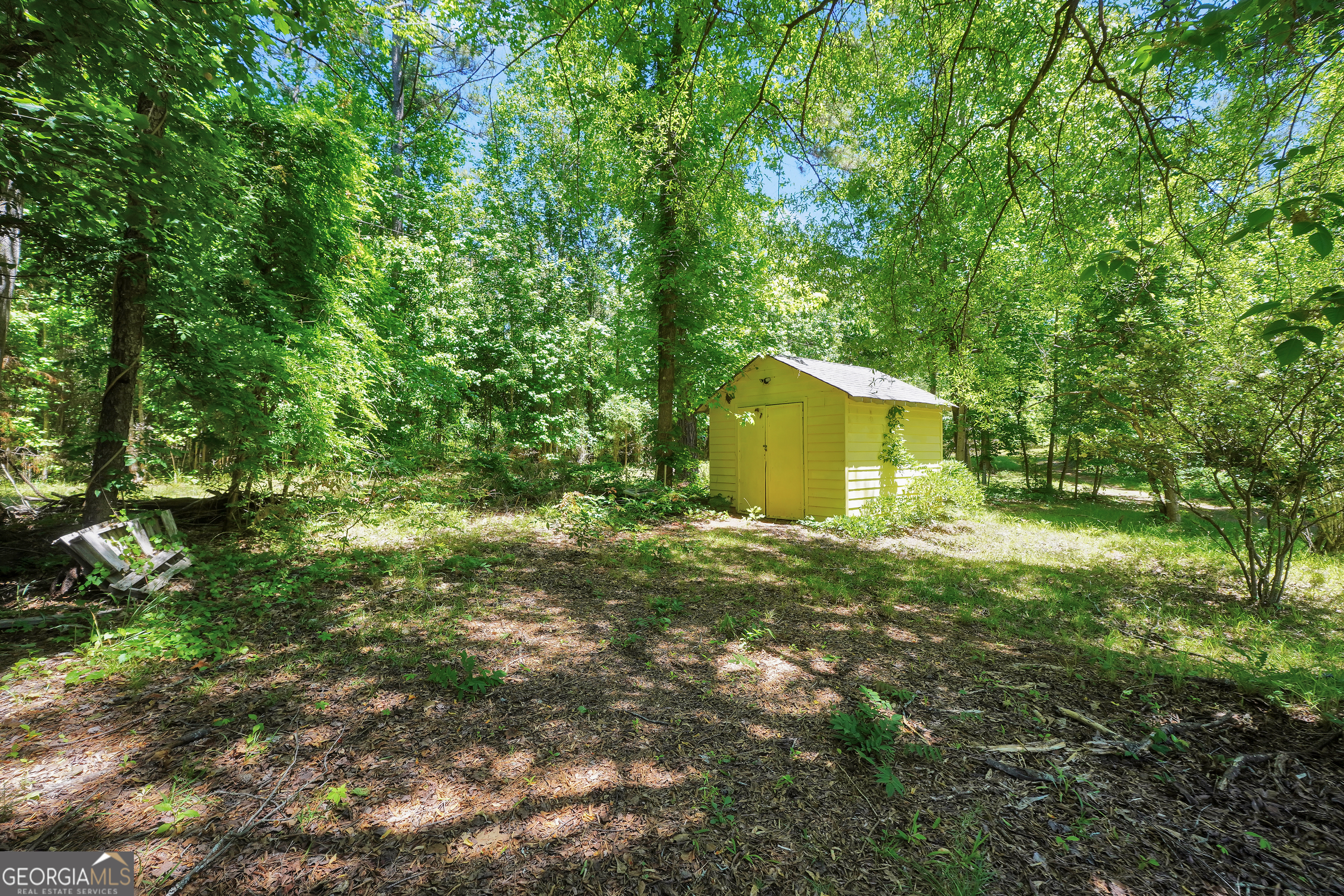 715 Concord Road Shady Dale, GA 31085 - Photo 32 of 38 a backyard of a house with a garden and plants