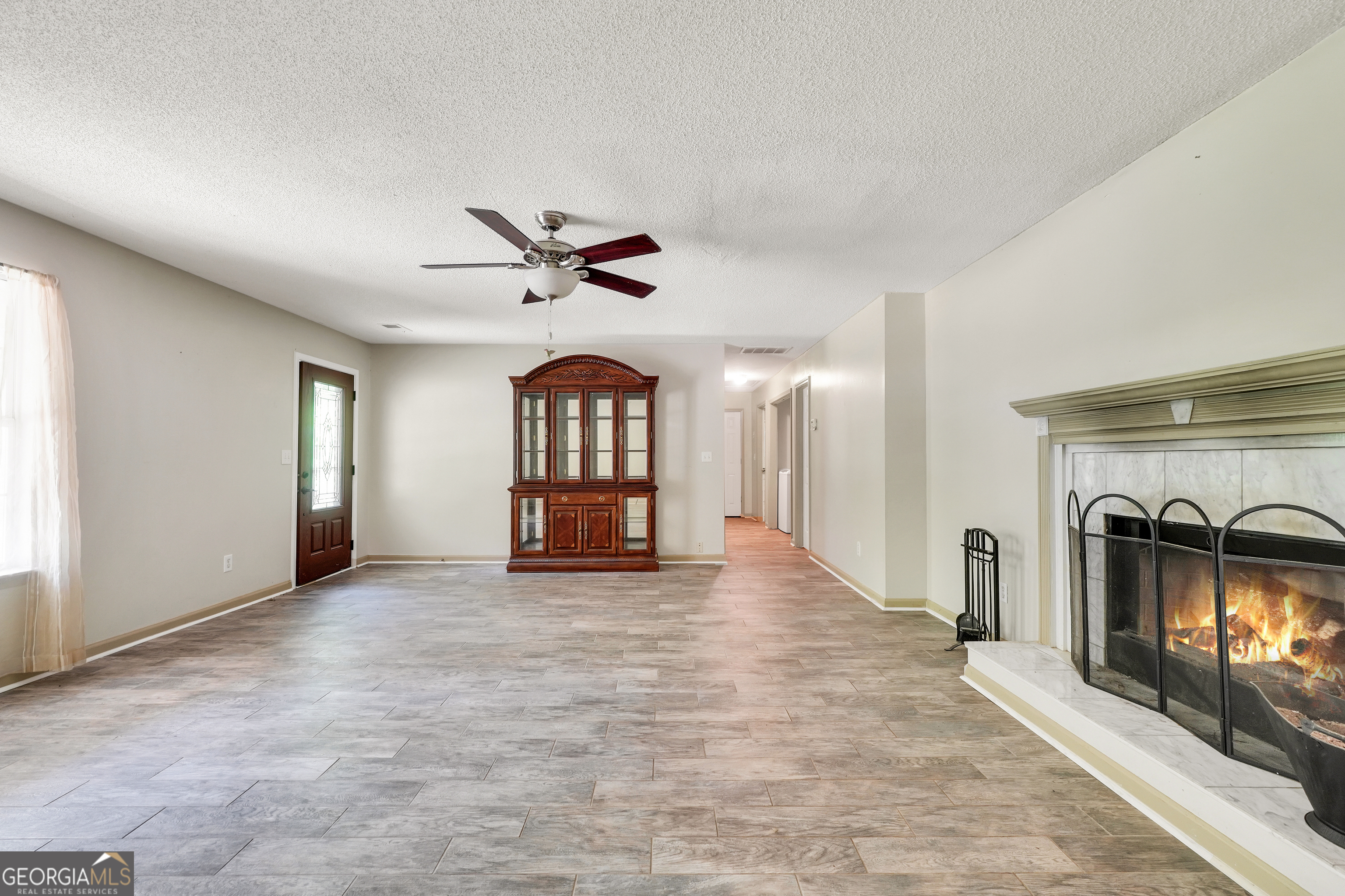 715 Concord Road Shady Dale, GA 31085 - Photo 4 of 38 an empty room with windows and fireplace