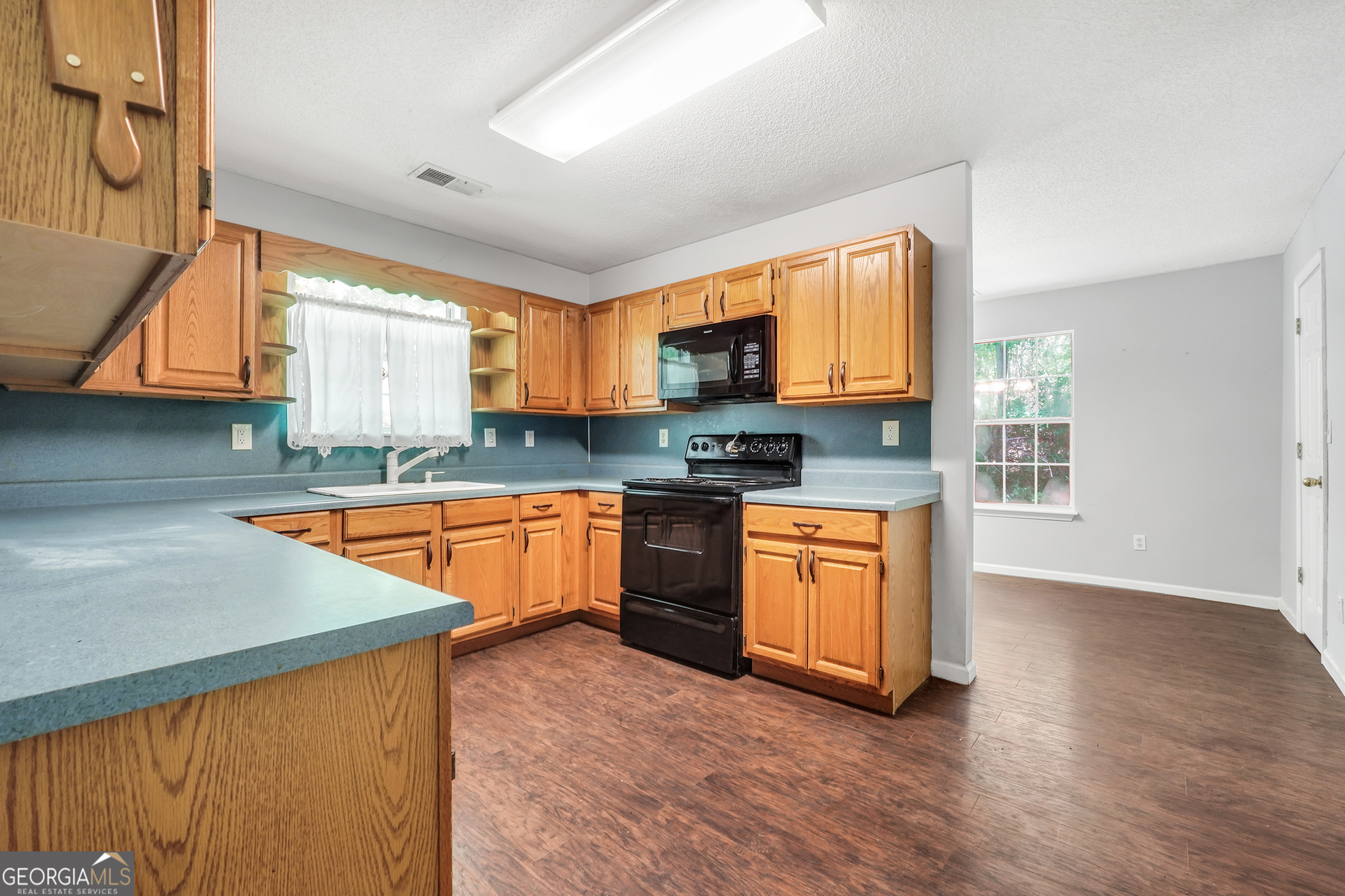 715 Concord Road Shady Dale, GA 31085 - Photo 6 of 38 a kitchen with stainless steel appliances granite countertop wooden cabinets a stove a sink and a window