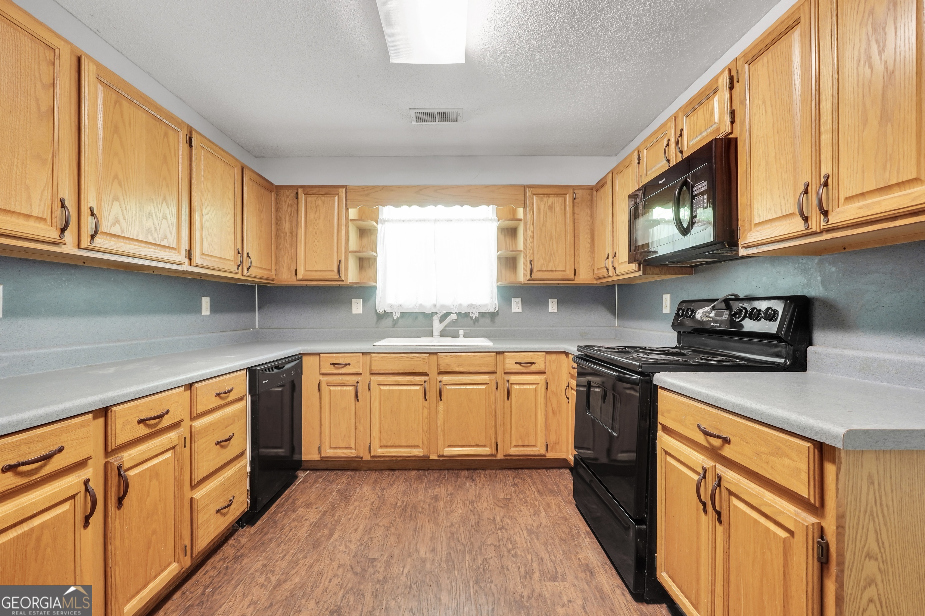 715 Concord Road Shady Dale, GA 31085 - Photo 7 of 38 a kitchen with stainless steel appliances granite countertop a stove a sink and a microwave