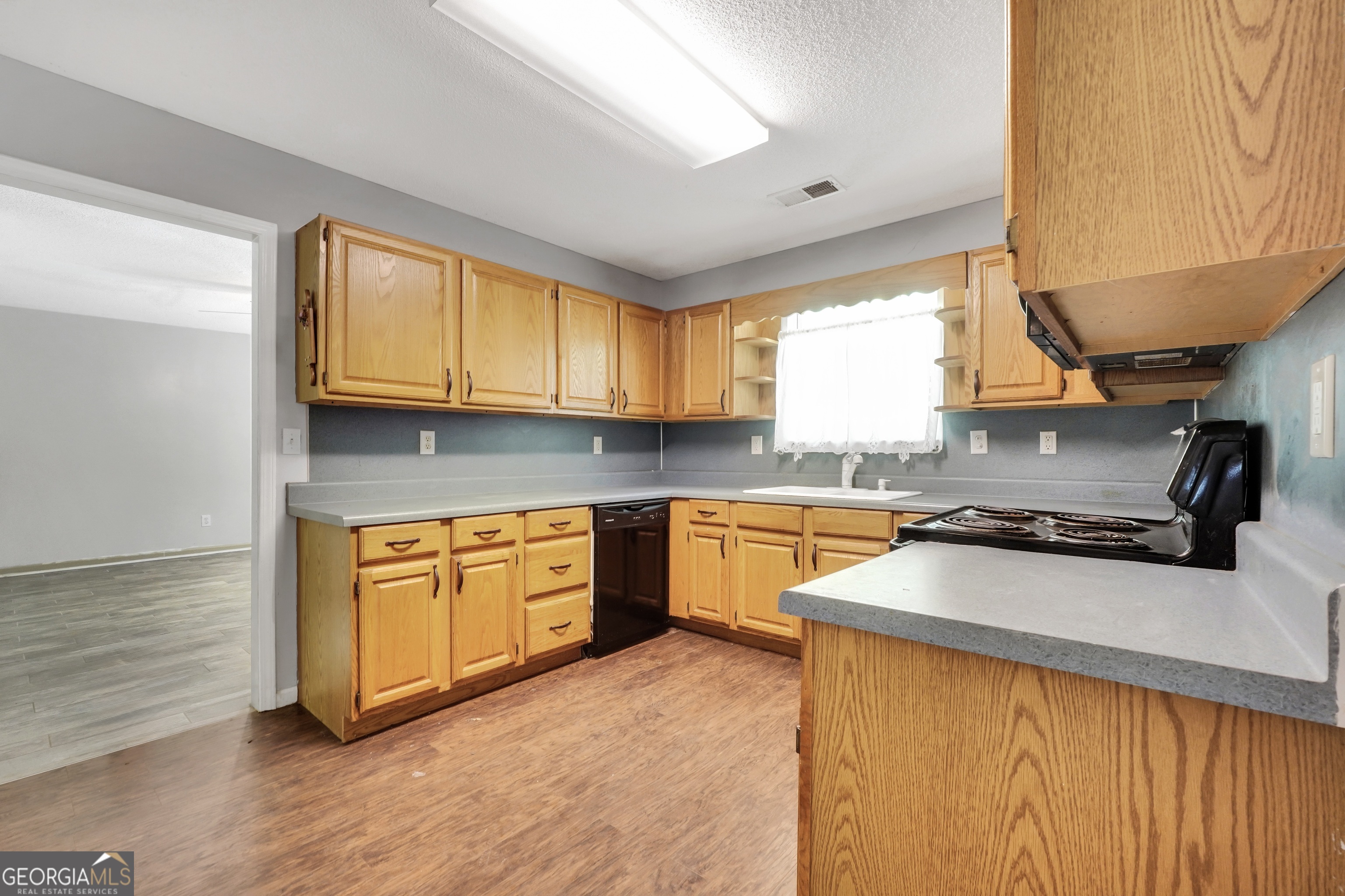 715 Concord Road Shady Dale, GA 31085 - Photo 9 of 38 a kitchen with stainless steel appliances granite countertop wooden cabinets a stove a sink and a window