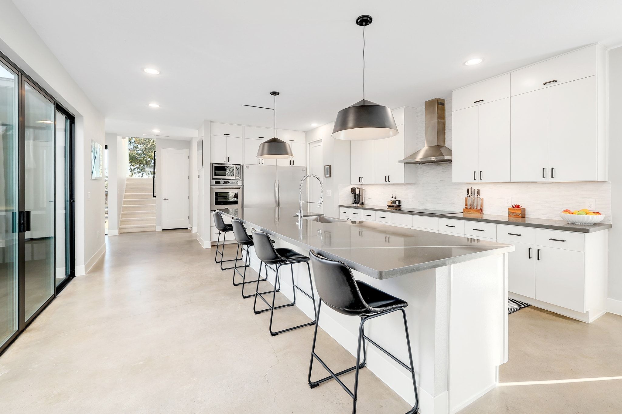 5710 Longhorn Landing Austin, TX 78734 - Photo 8 of 37 a kitchen with stainless steel appliances kitchen island granite countertop a sink a stove a refrigerator and white cabinets