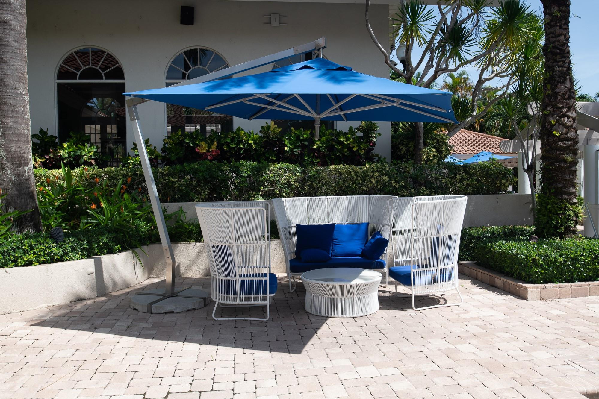 6192 Northwest 24th Street Boca Raton, FL 33434 - Photo 47 of 57 a view of a patio with a table and chairs under an umbrella with potted plants